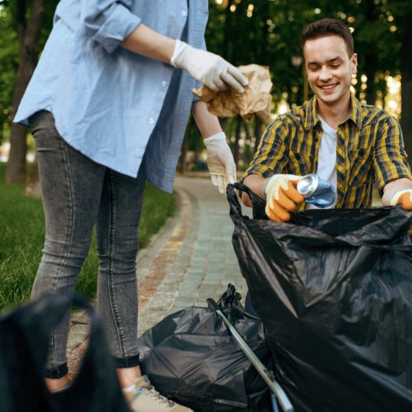 Volunteers picking trash in park, volunteering. Male person cleans forest, ecological restoration, eco lifestyle, garbage collection and recycling, ecology care, environment cleaning